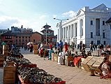 Kathmandu Durbar Square 01 01 Basantpur Square Market Just Outside Durbar Square Basantapur Square is a large open plaza at the south-eastern entrance to Kathmandu Durbar Square, where souvenir sellers set up their stalls in long lines to await the tourists. The white columned building on the right is the Gaddi Baithak, part of the Royal Palace complex built in the 1908 after King Jung Bahadur Rana returned from a trip to England, where he developed a taste for western neo-classical architecture. The main part of Durbar Square is straight ahead.